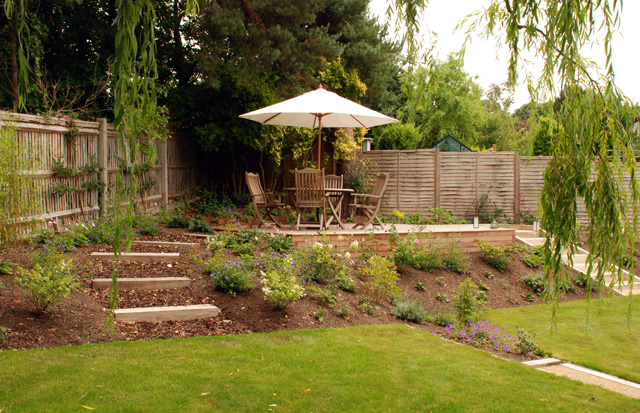 View of deck from under willow tree Lisa Cox Garden Designs Surrey